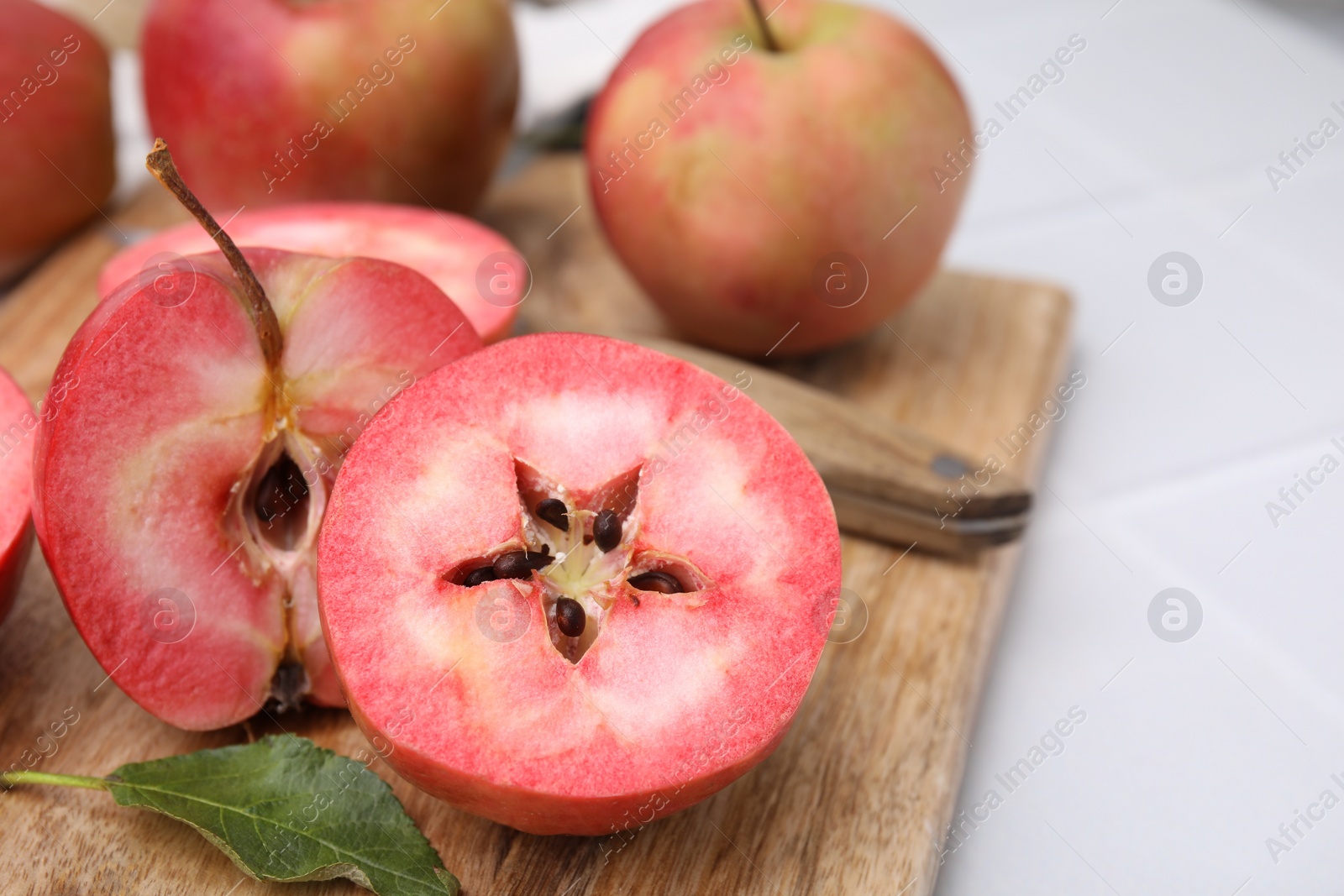 Photo of Tasty apples with red pulp on table, closeup