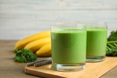 Photo of Tasty fresh kale smoothie on wooden table, closeup