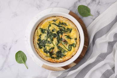 Photo of Delicious pie with spinach on white marble table, flat lay