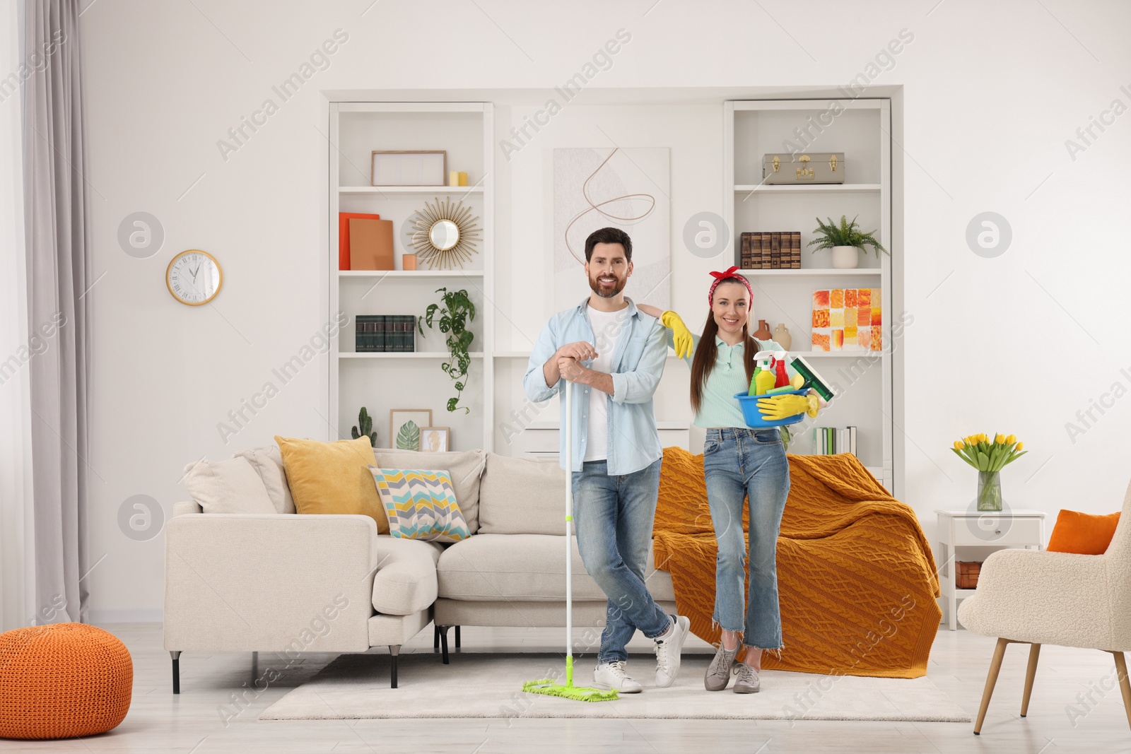 Photo of Spring cleaning. Couple with detergents and mop in living room