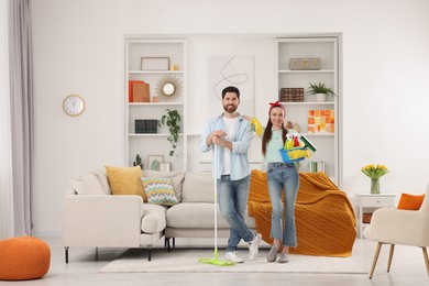 Spring cleaning. Couple with detergents and mop in living room