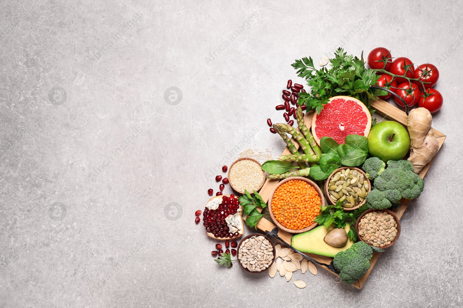 Photo of Fresh vegetables, fruits and seeds on grey table, flat lay. Space for text