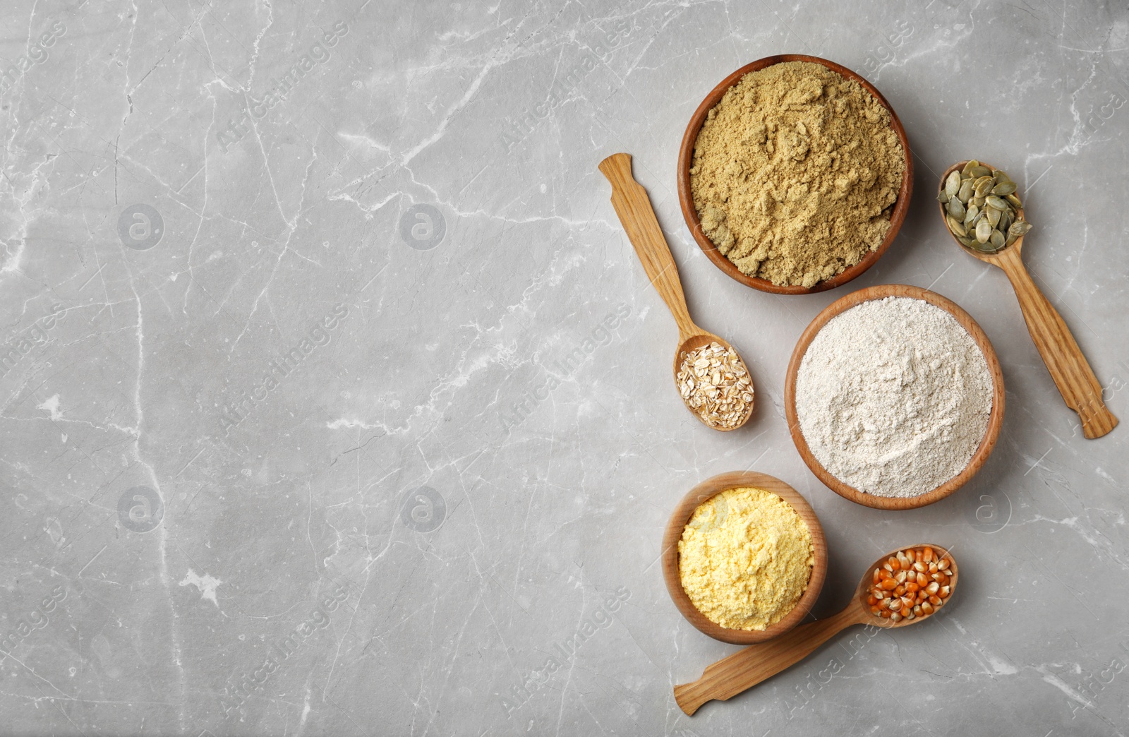 Photo of Bowls with different types of flour on light background