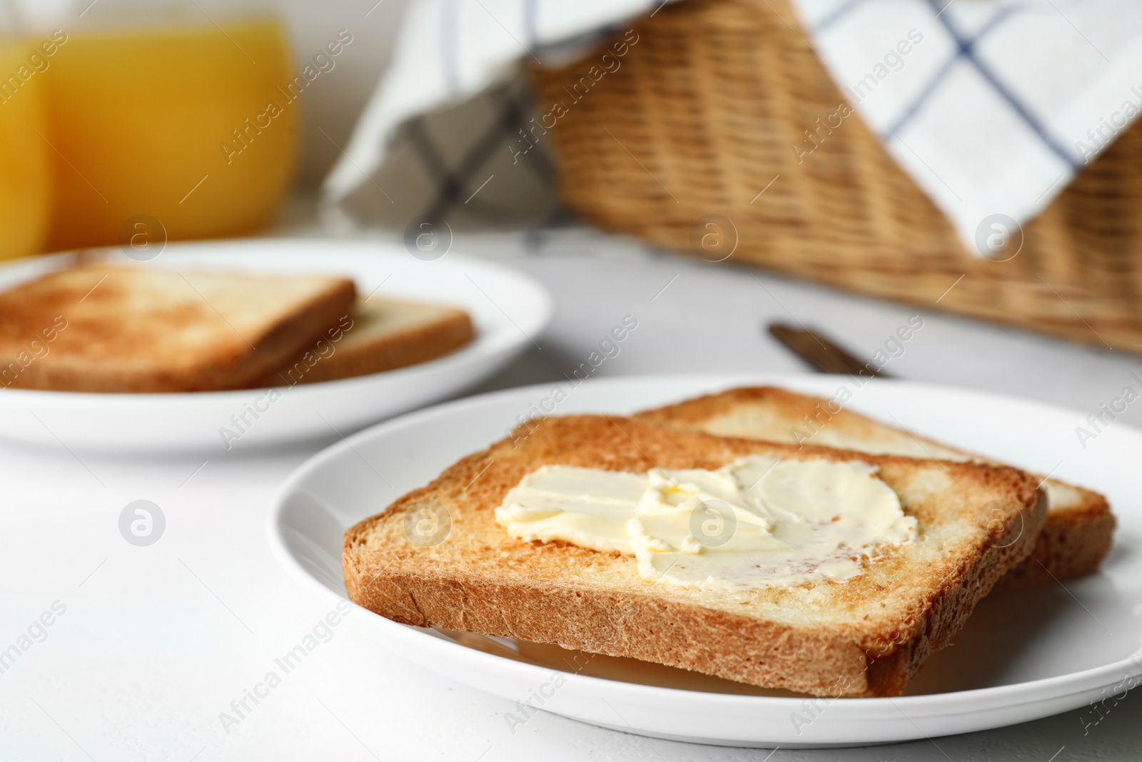 Photo of Slices of toasted bread with butter on white table