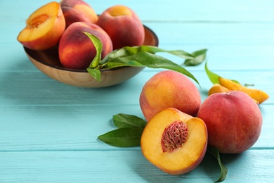 Photo of Fresh sweet peaches on turquoise wooden table
