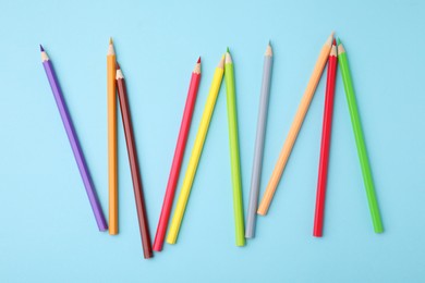 Photo of Colorful wooden pencils on light blue background, flat lay