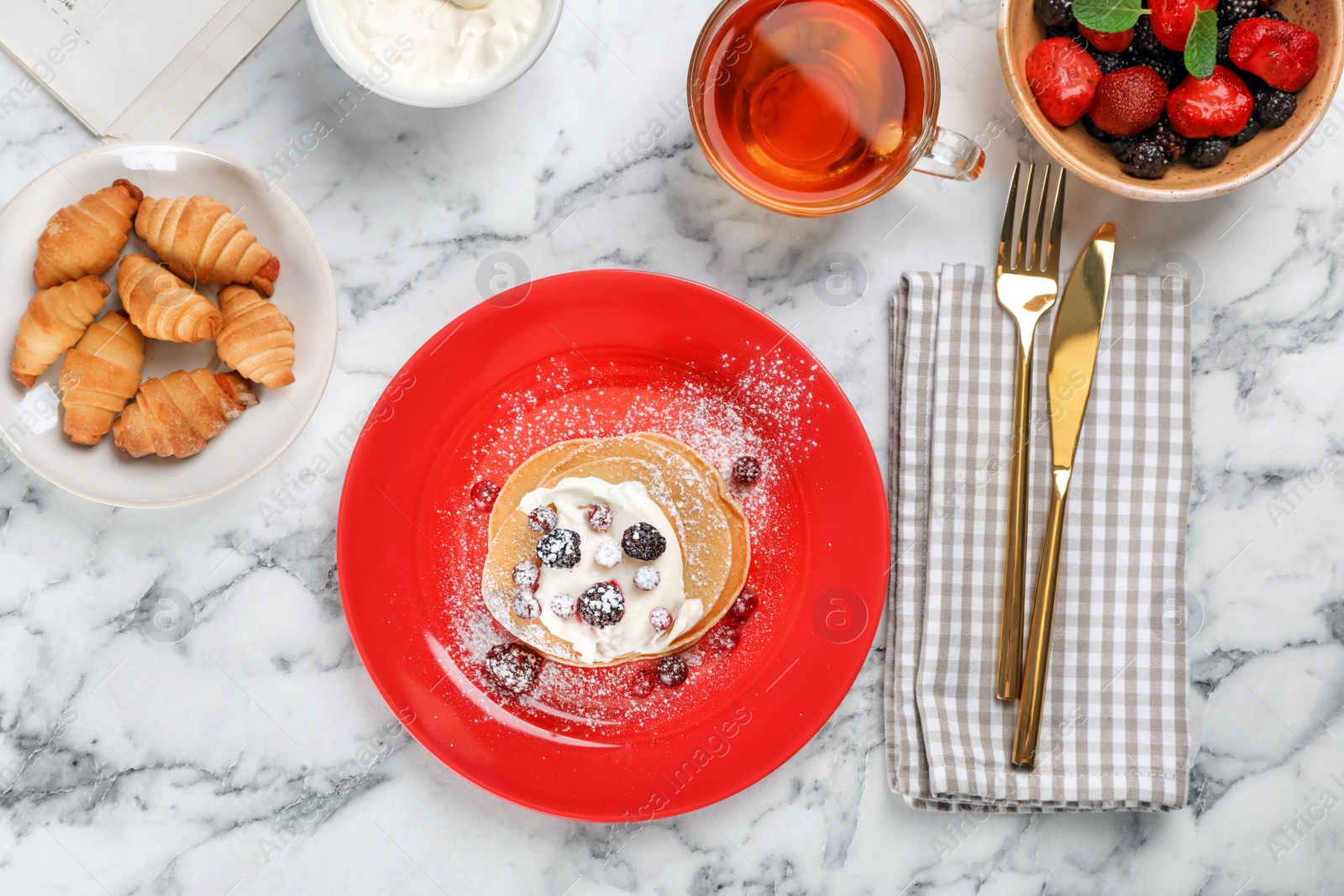 Photo of Delicious pancakes with berries and cream served for breakfast on table