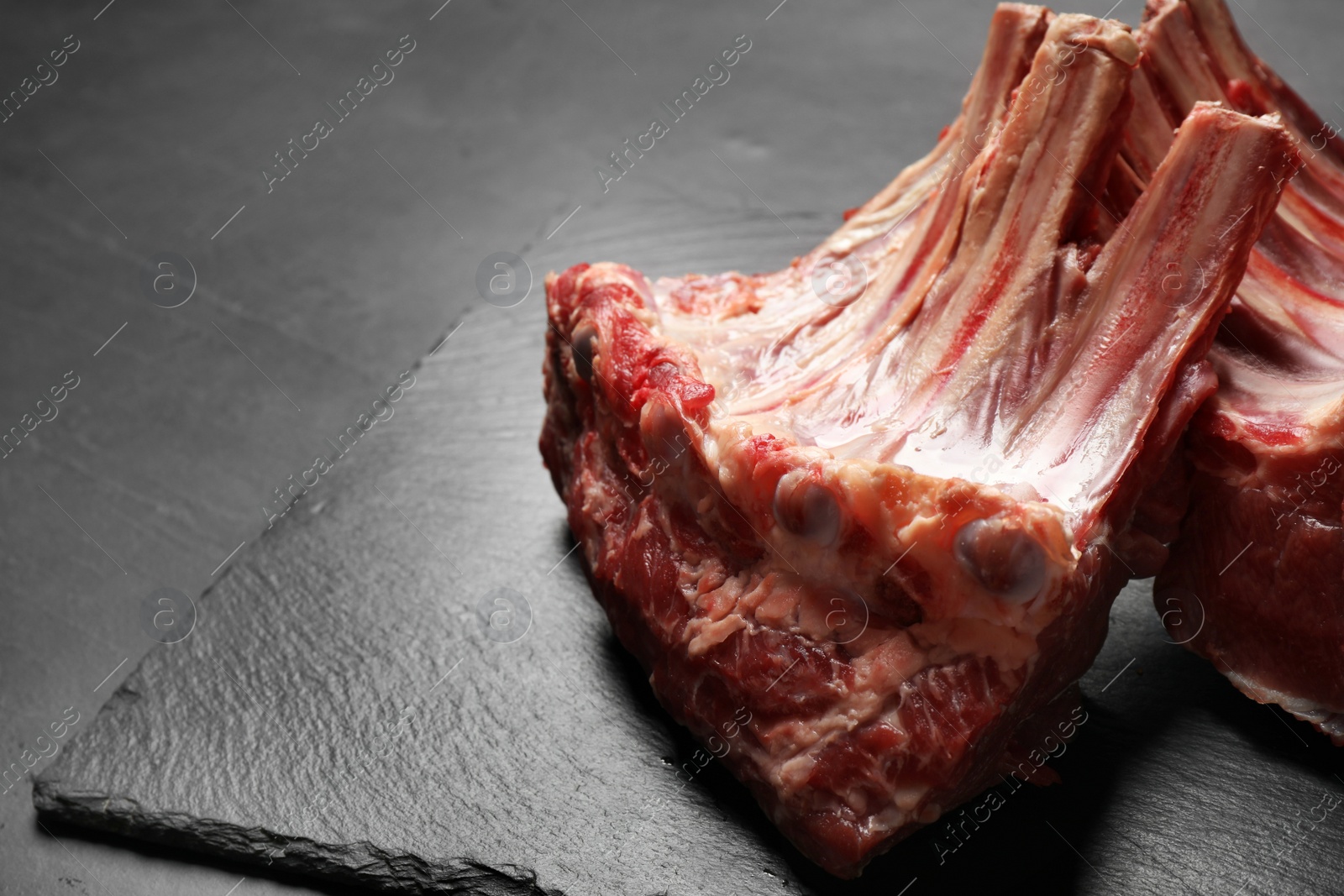 Photo of Raw ribs on slate board, closeup. Fresh meat