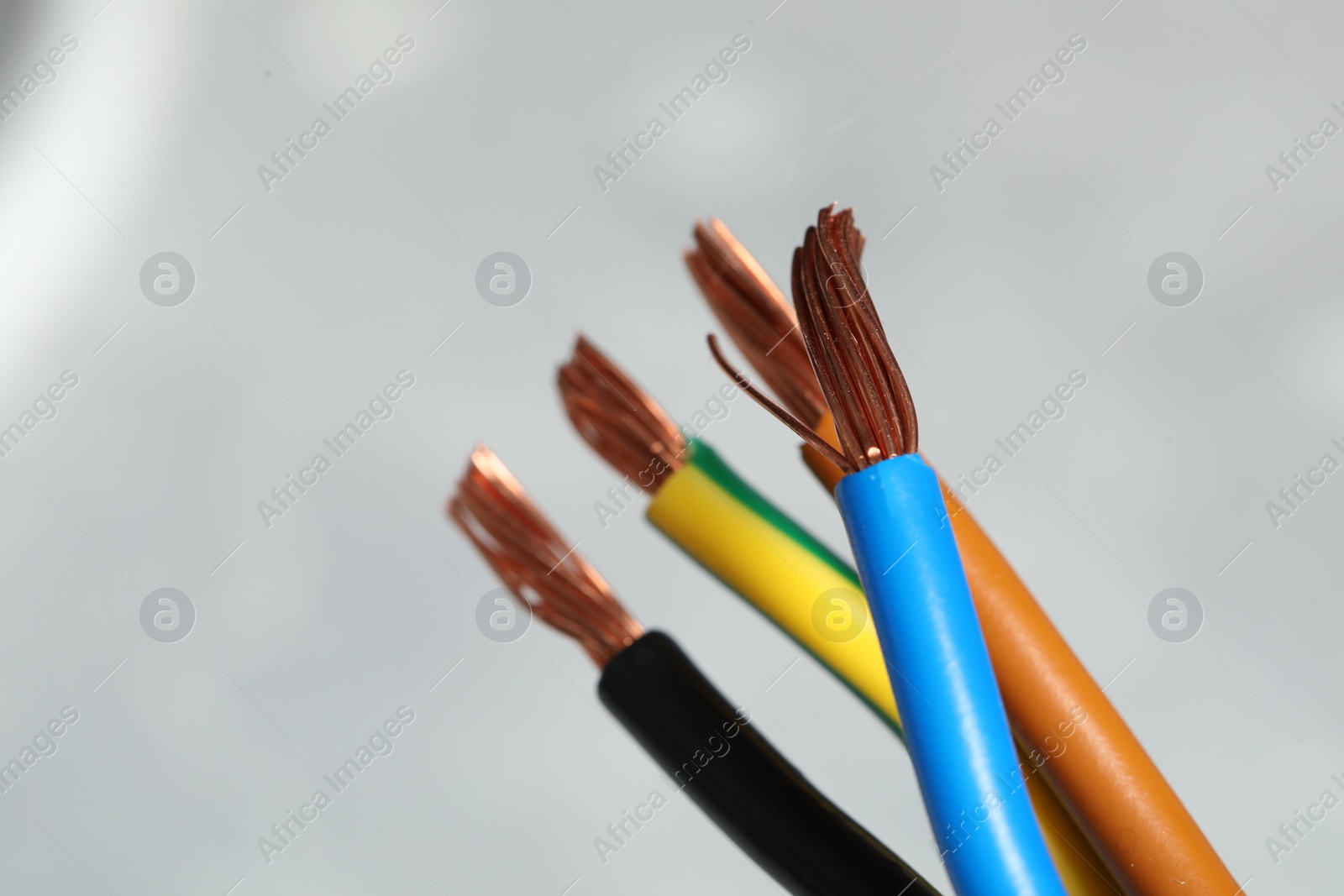 Photo of Colorful electrical wires on blurred background, closeup. Space for text