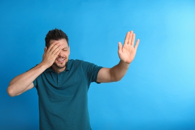 Photo of Man covering eye while being blinded on blue background