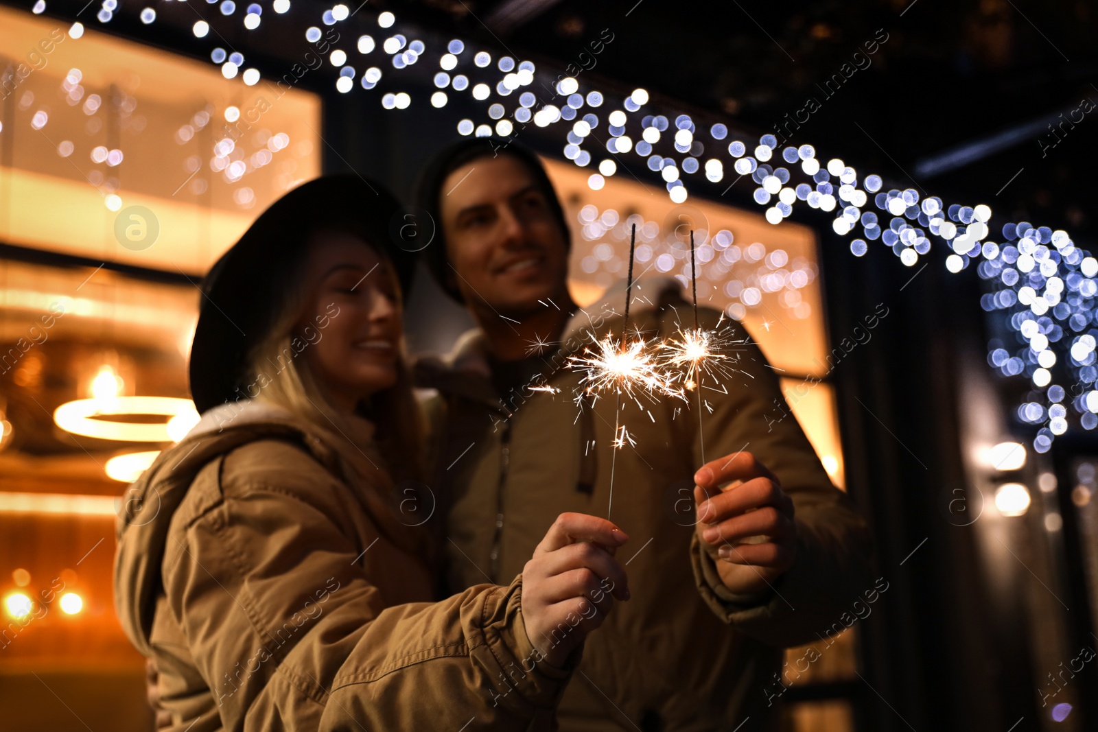 Photo of Happy couple with sparklers at winter fair