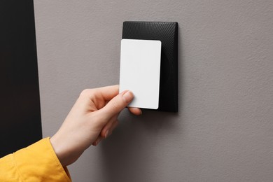 Photo of Woman opening magnetic door lock with key card, closeup. Home security