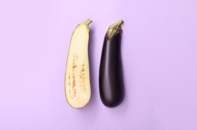 Photo of Halves of raw ripe eggplant on light background, flat lay