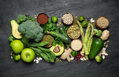 Photo of Different vegetables, seeds and fruits on black table. Healthy diet