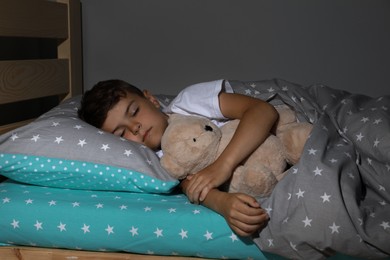 Cute little boy sleeping with teddy bear at home. Bedtime