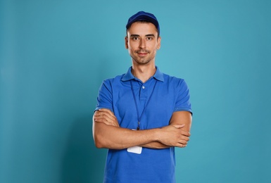 Portrait of happy young courier on blue background