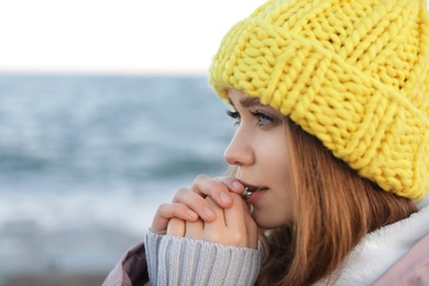 Portrait of beautiful young woman near sea, closeup. Space for text