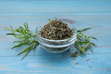 Photo of Dry and fresh tarragon on light blue wooden table