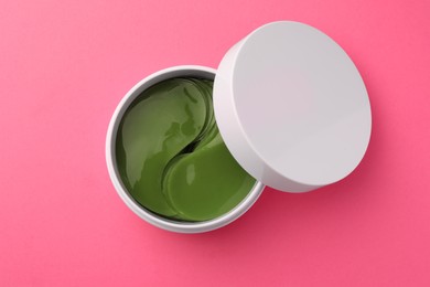 Photo of Jar of under eye patches on pink background, top view. Cosmetic product