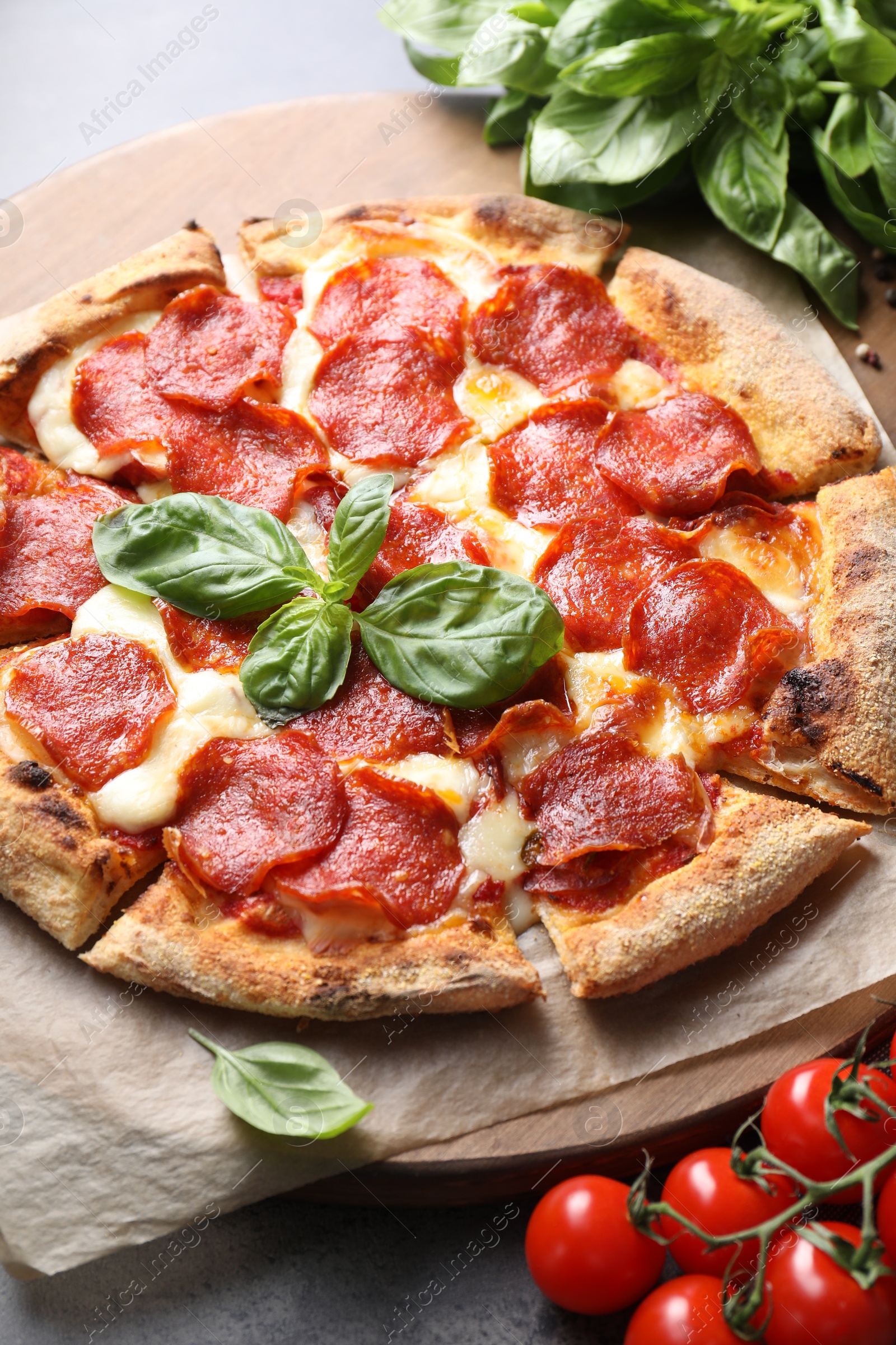 Photo of Tasty pepperoni pizza and ingredients on table