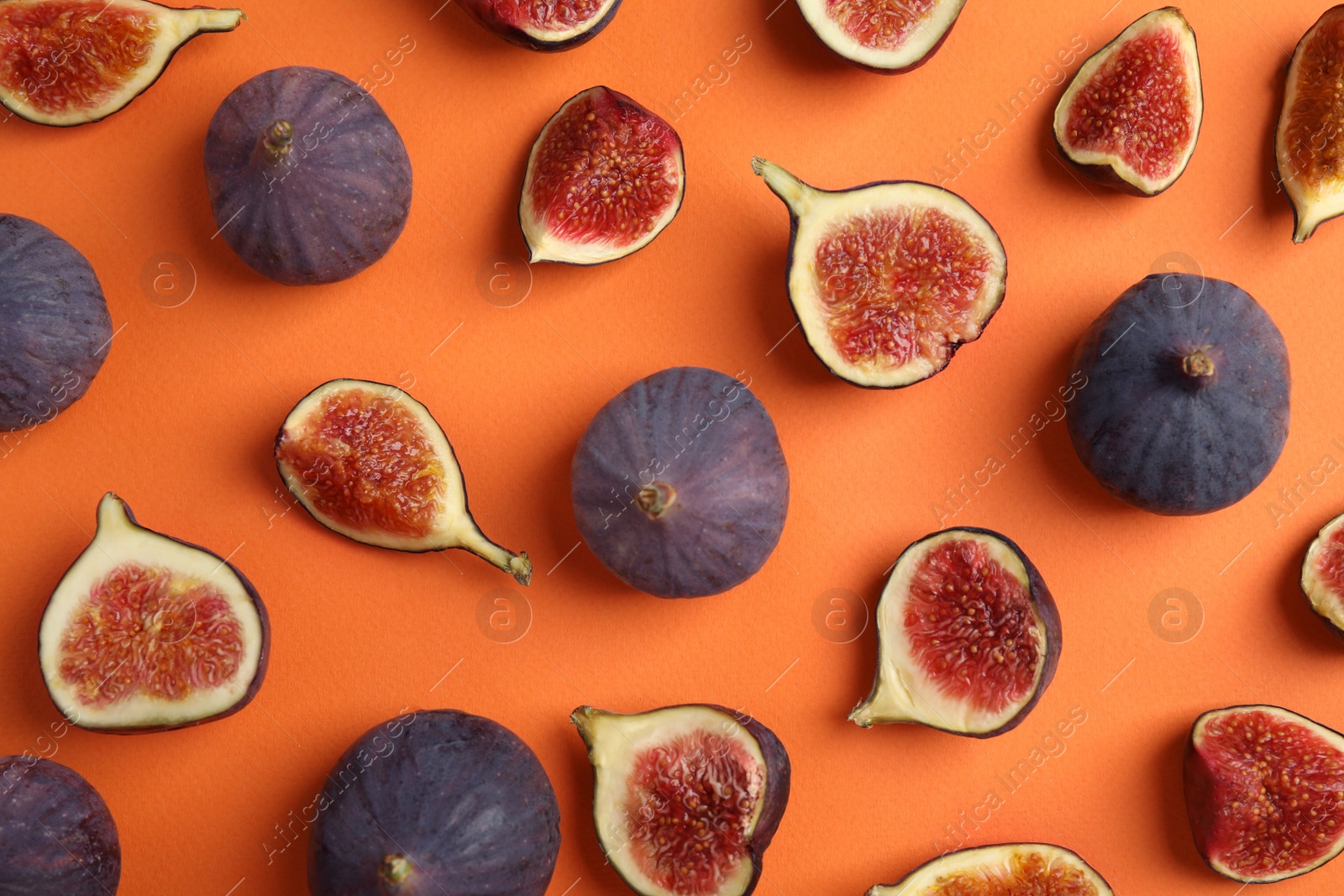 Photo of Delicious ripe figs on orange background, flat lay