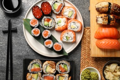 Photo of Flat lay composition with delicious sushi rolls on dark grey table