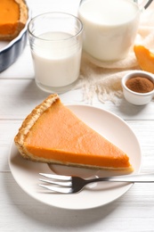 Photo of Plate with piece of fresh delicious homemade pumpkin pie on wooden table