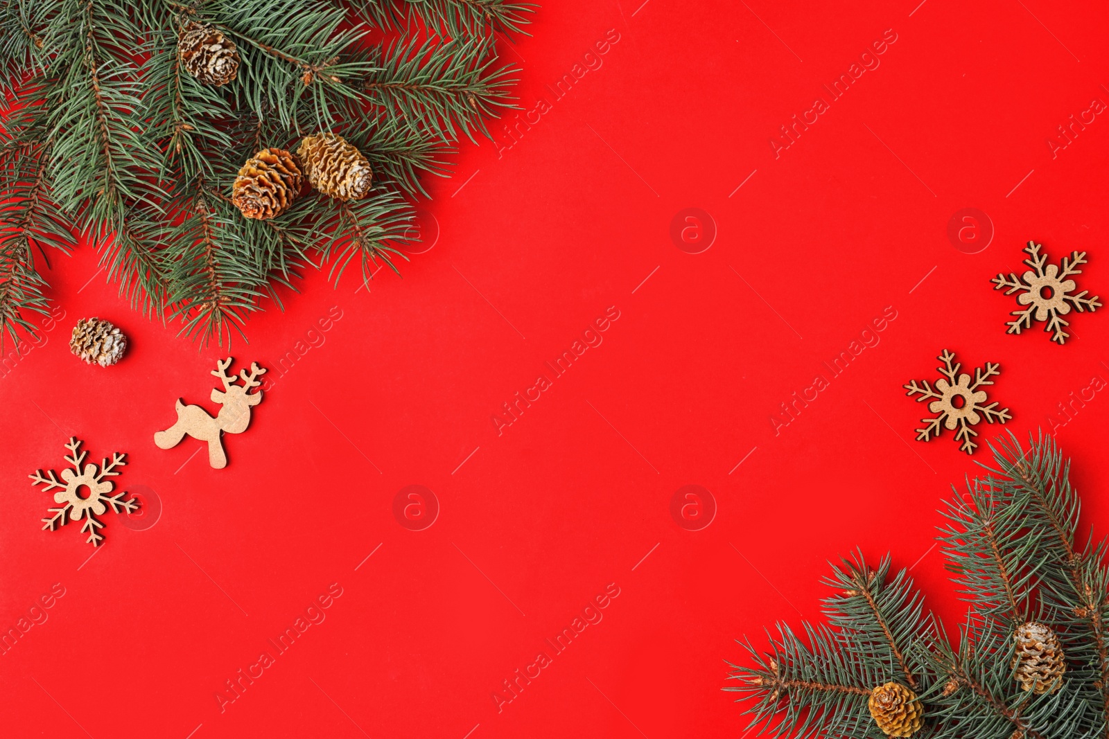 Photo of Christmas flat lay composition with fir branches on red background, space for text. Winter holidays