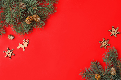 Christmas flat lay composition with fir branches on red background, space for text. Winter holidays