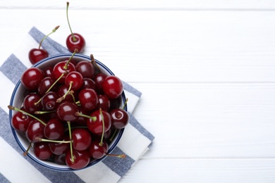 Photo of Sweet juicy cherries on white wooden table, top view. Space for text