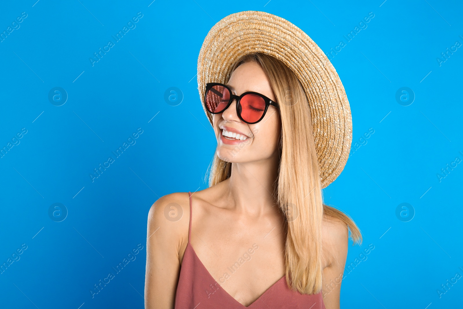 Photo of Beautiful woman in stylish sunglasses on light blue background