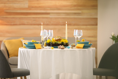 Photo of Festive Easter table setting with beautiful floral decor and eggs indoors