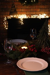Plates, glasses and festive decor on wooden table
