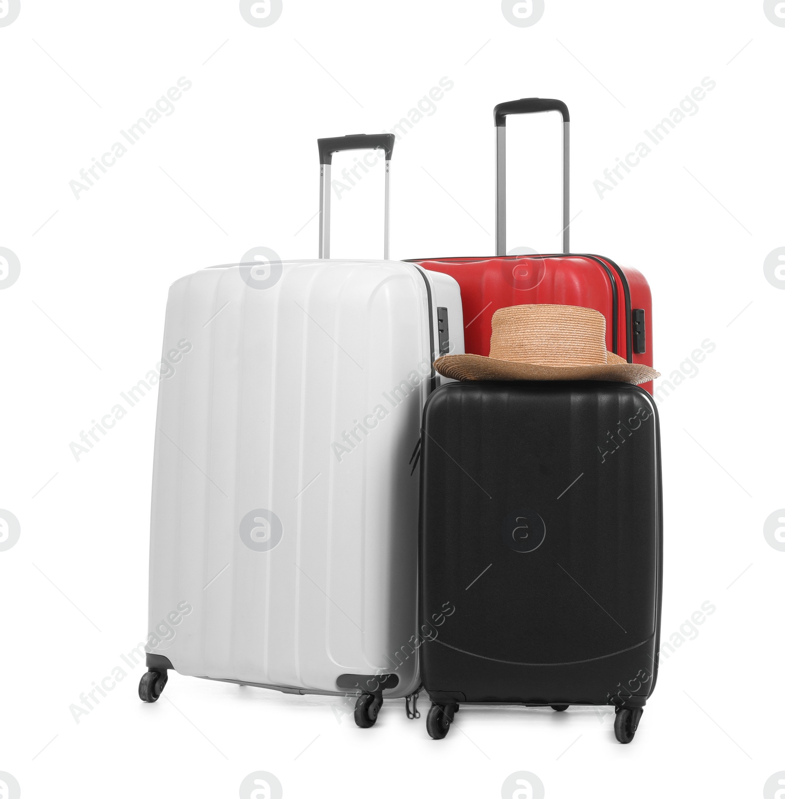 Photo of New suitcases and hat packed for journey on white background