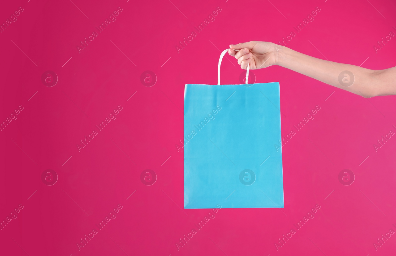 Photo of Woman holding shopping bag on color background, closeup.  Mock-up for design