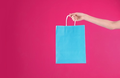 Woman holding shopping bag on color background, closeup.  Mock-up for design