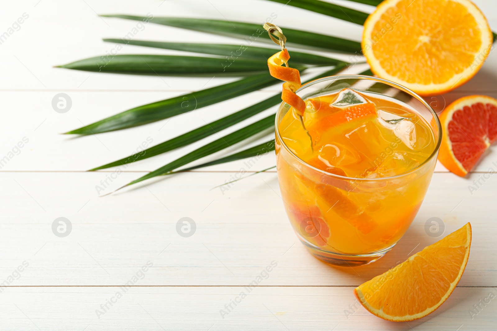 Photo of Delicious orange soda water on white wooden table. Space for text