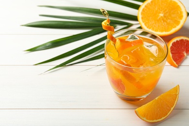 Delicious orange soda water on white wooden table. Space for text