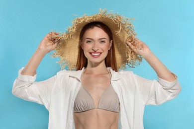 Photo of Beautiful young woman in straw hat on light blue background