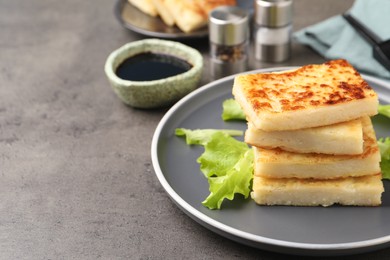 Photo of Delicious turnip cake with lettuce salad served on grey table. Space for text