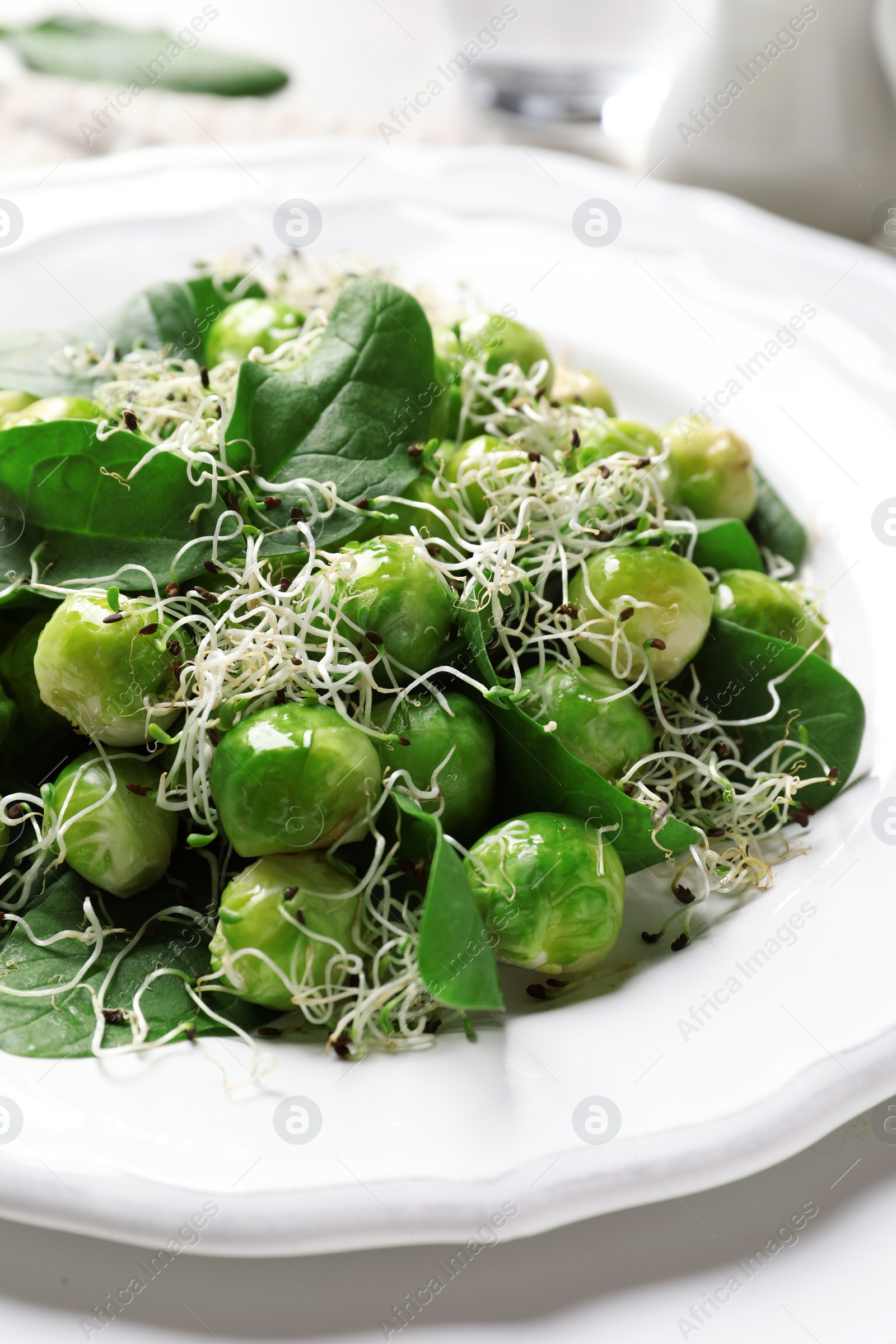 Photo of Plate of delicious salad with Brussels sprouts on table