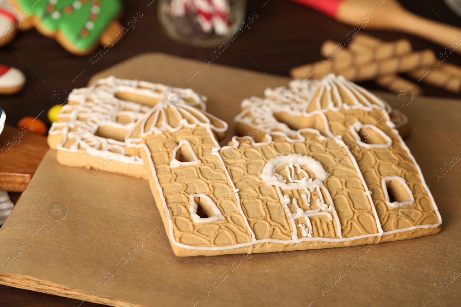 Photo of Parts of gingerbread house on parchment, closeup