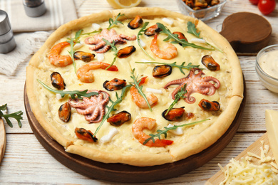Delicious seafood pizza on white wooden table, closeup