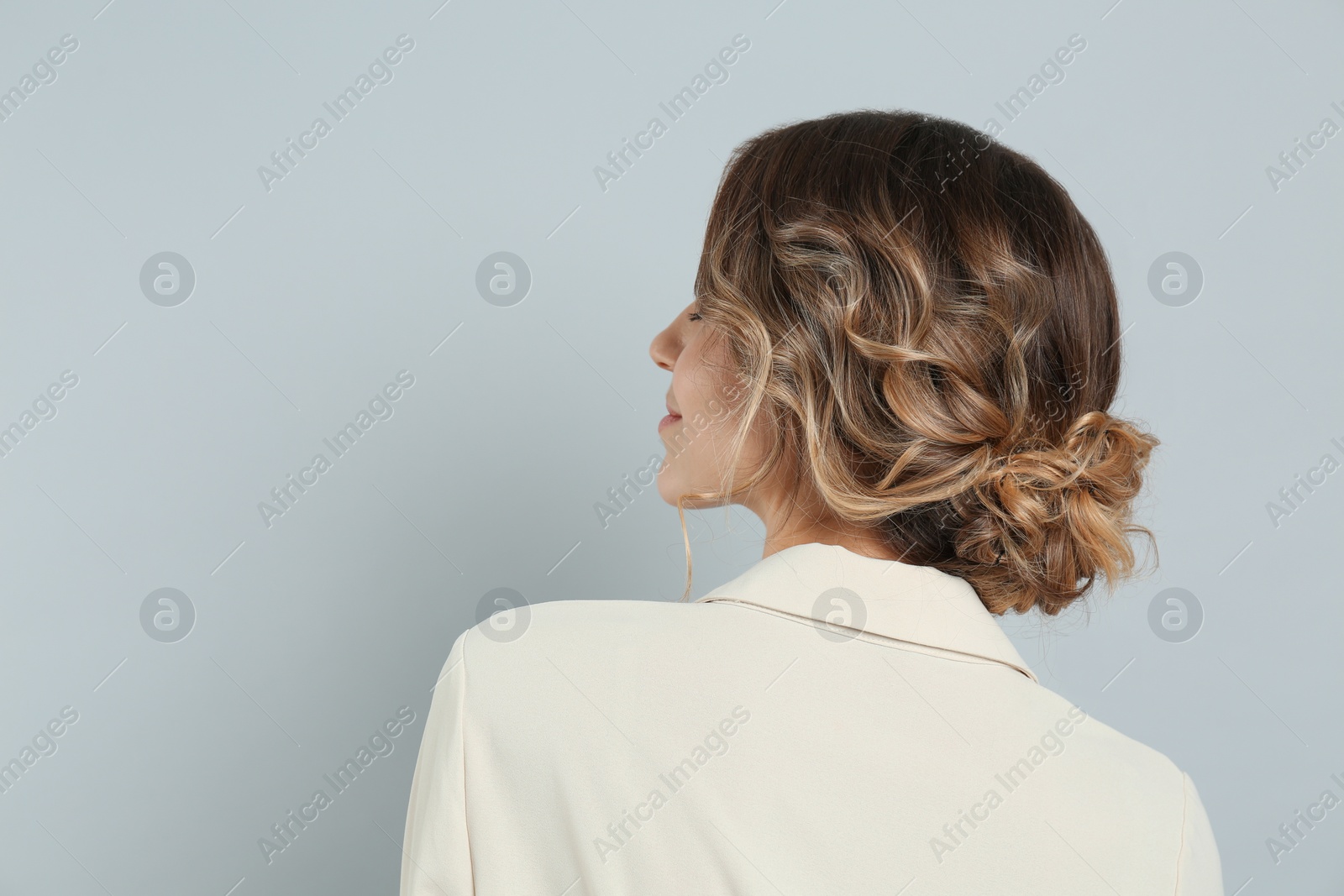 Photo of Young woman with beautiful hairstyle on light grey background. Space for text