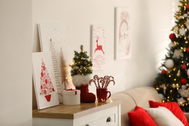 Beautiful Christmas pictures on chest of drawers indoors. Interior design