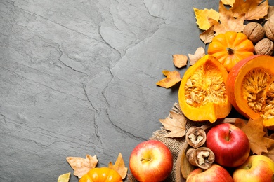 Photo of Flat lay composition with vegetables, fruits and autumn leaves on black slate table, space for text. Thanksgiving Day