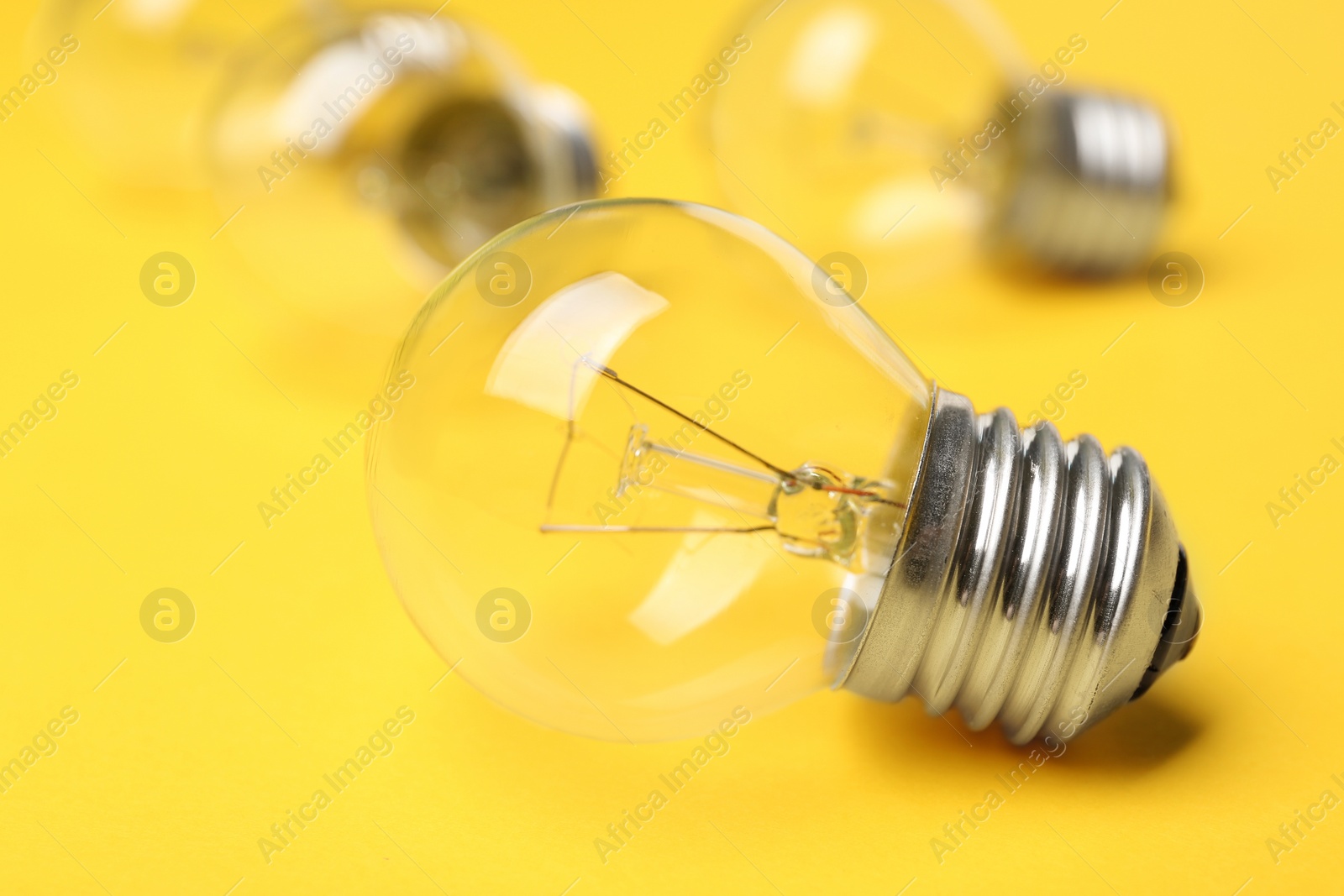 Photo of New incandescent lamp bulb on yellow background