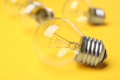 Photo of New incandescent lamp bulb on yellow background