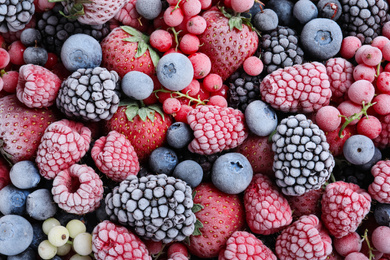 Photo of Mix of different frozen berries as background, top view