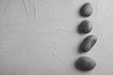 Zen stones on grey background, top view with space for text